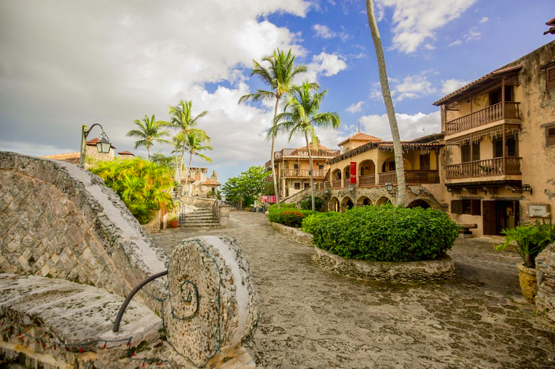 Picturesque view of the village of Altos de Chavón with stone buildings and palm trees.